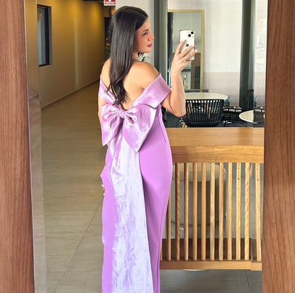 Abito in crep lilla con scollo a spalle scoperte e drappeggio elegante.