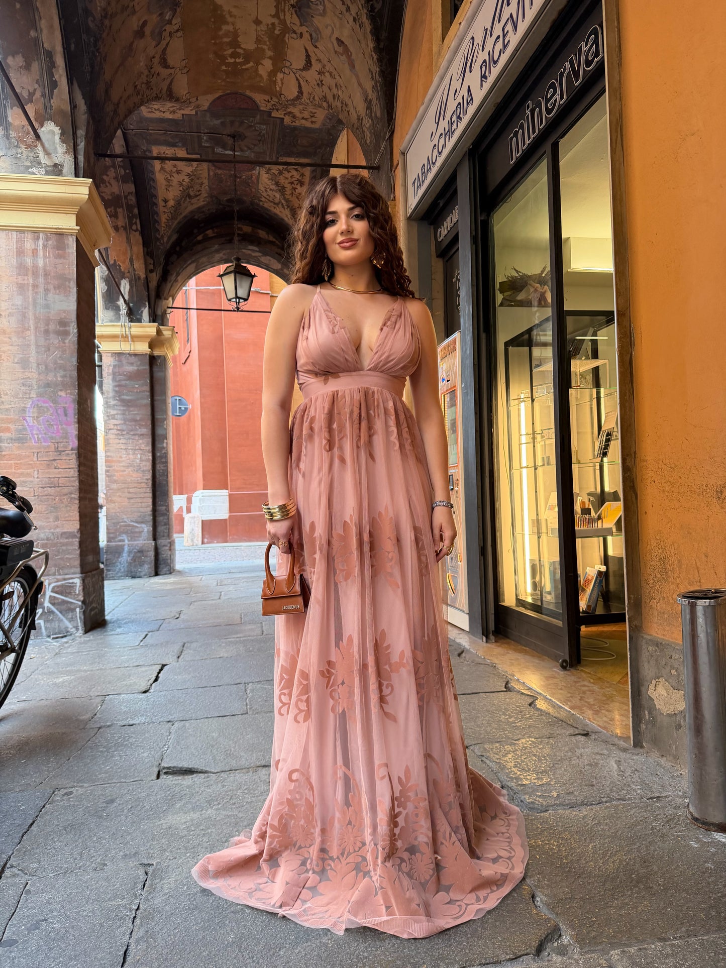 Abito lungo in tulle rosa cipria con stampa floreale e scollo incrociato sulla schiena.